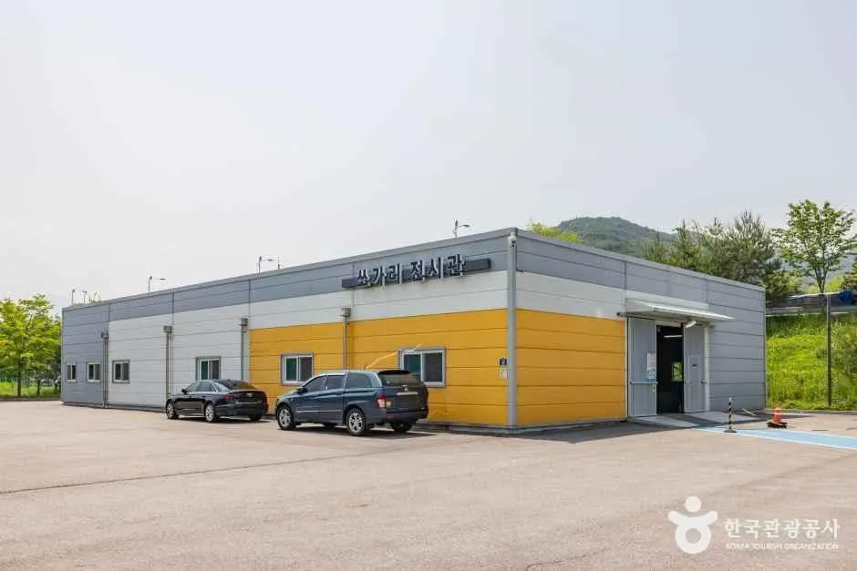 노란 벽면에 '쏘가리 전시관' 간판이 붙은 야외 전시동 건물