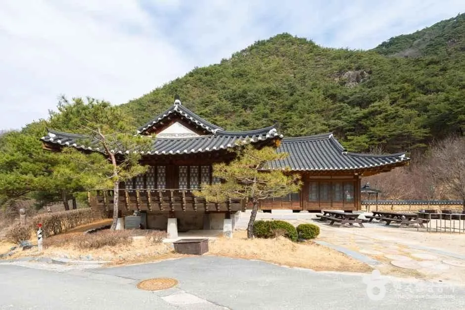 산자락 아래 소나무 옆에 선 성불산자연휴양림의 한옥 건물